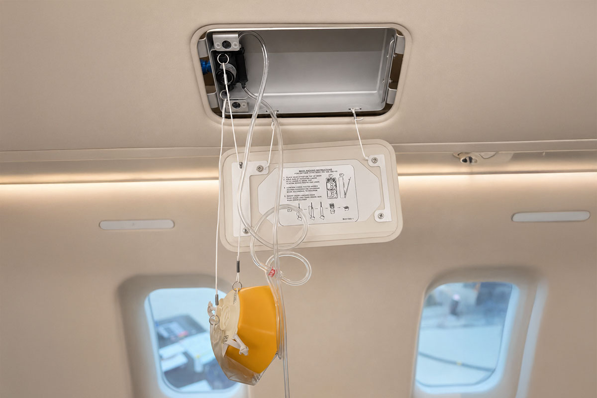 Inside a cabin emergency training simulator showing a close up of an oxygen mask that has been deployed from ceiling to be used